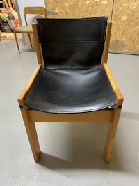 a black leather chair sitting on a wooden floor
