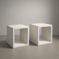 two white cube side tables on a grey floor