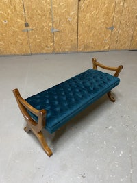 a bench with a blue velvet upholstered seat